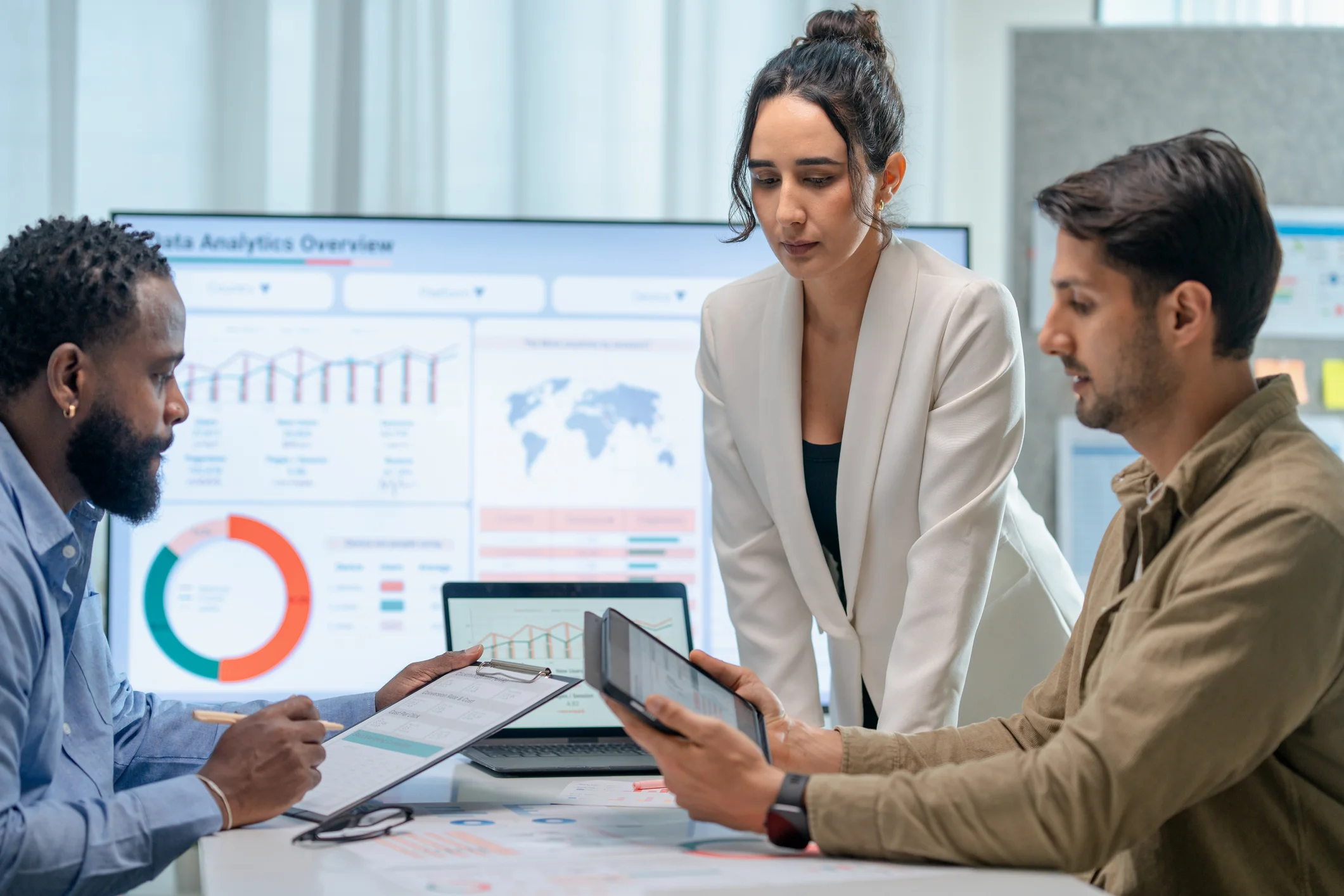 Team of professionals analyzing government contracting data on a large dashboard display with charts, graphs, and analytics visualizations for federal procurement strategy