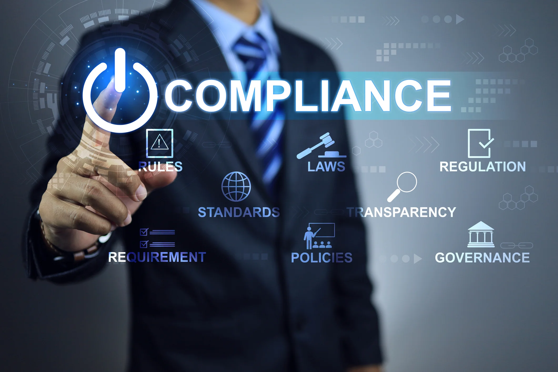 Business professional in suit touching a glowing holographic compliance power button surrounded by federal contracting compliance icons — Rules, Laws, Regulation, Standards, Transparency, Requirement, Policies, and Governance — representing government contractor insurance and FAR compliance obligations